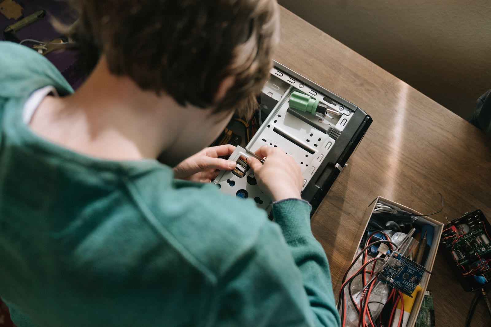 Hands fitting a drive tray into an open desktop computer case